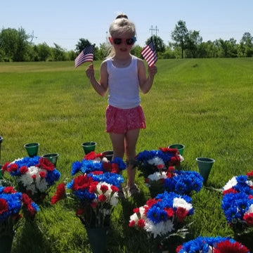 girl standing with flowers at the fort snelling cemetery